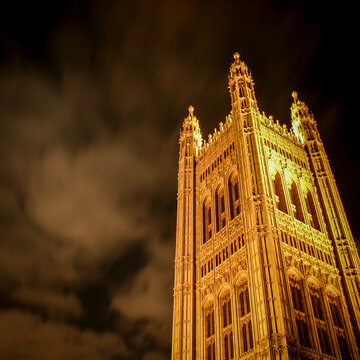 Victoria Tower Pinnacle. Low angle view of historic palace architecture illuminated against a dark cloudy night sky.