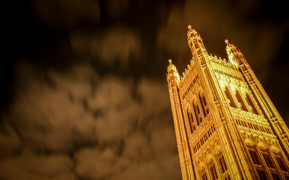 Victoria Tower Pinnacle. Low angle view of historic palace architecture illuminated against a dark cloudy night sky.