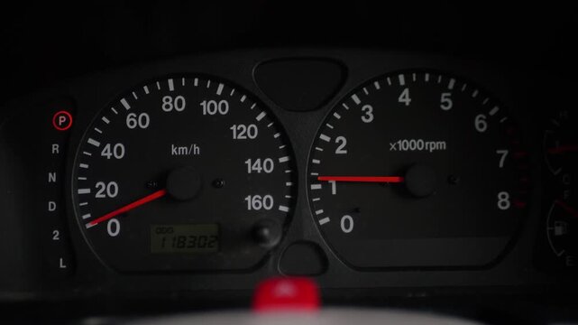 Close-up of car tachometer needle rising and falling on dashboard. Engine rpm fluctuation, acceleration, idling, diagnostics, vehicle performance.