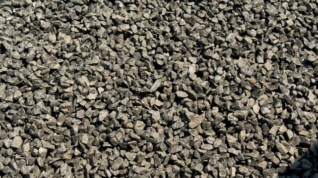 Closeup view of a textured gravel surface with various shades of gray and brown stones