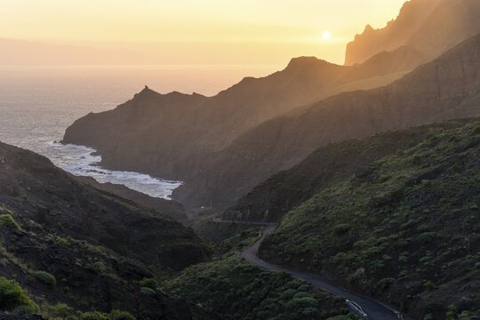 View of Punta San Lorenzo, Punta Sabina and the road to Playa de La Caleta. In the morning, golden hour, good weather, mist rising in the valleys. La Gomera, Canary Islands, Spain