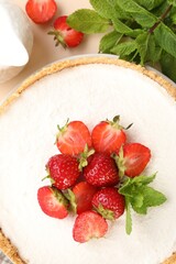 Naklejka premium Yummy cheesecake with strawberries and mint on beige table, flat lay
