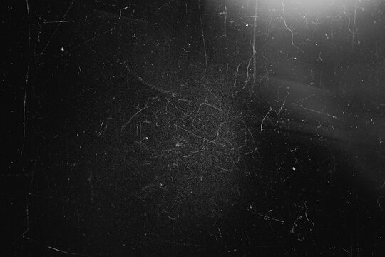 Distressed black texture background with heavy center scratches and top right lens flare