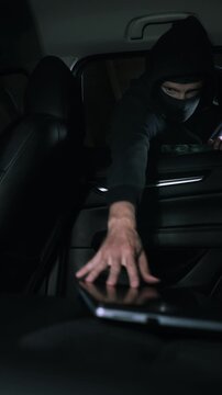 Car items theft - robber steals laptop from car interior through window