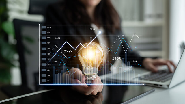 A business professional showcases a glowing lightbulb representing innovative ideas amid charts and analytics in a contemporary office environment. Scalp