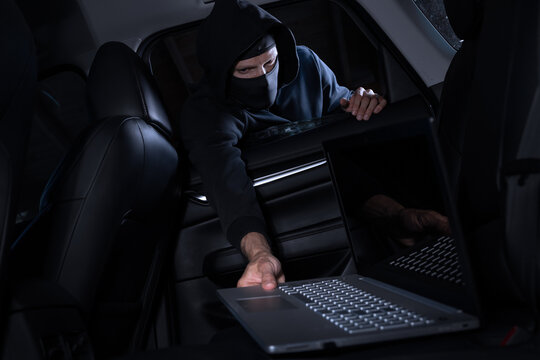 Car items theft - robber steals laptop from car interior through window