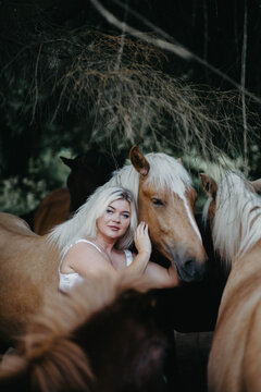 A woman with white hair next to a horse with a white mane. Concept of hair strength and health.