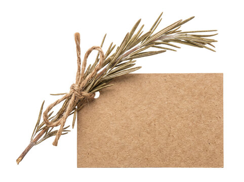 Rosemary sprig kraft paper labels tied with twine bow on black background. Blank rustic cardboard gift tag for organic branding mockup, culinary herb packaging design concept with available copy space