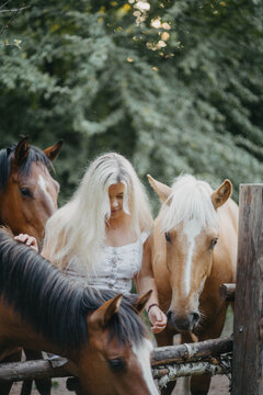 A woman with white hair next to a horse with a white mane. Concept of hair strength and health.