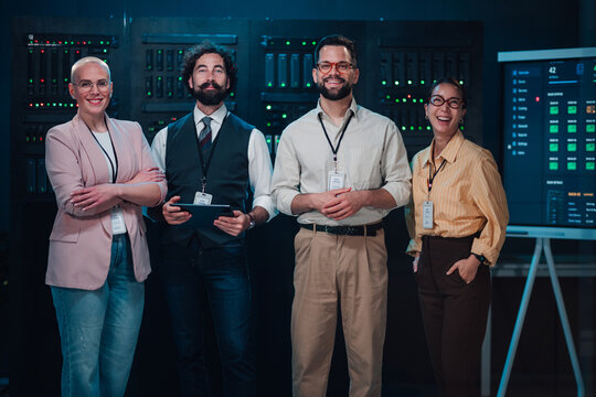 Diverse it team smiling, managing a critical server room, ensuring network security and reliable data processing operations