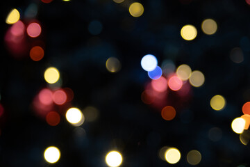 Fototapeta premium Abstract blurred background with colorful bokeh lights in various shades of yellow, red, and blue. Soft focus creates a dreamy effect.