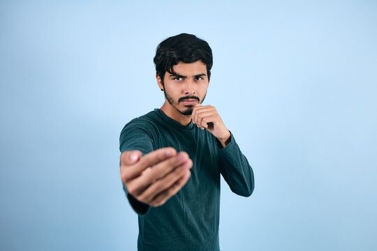 portrait of young latin man in fighting pose on blue background in Mexico Latin America