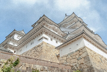 Fototapeta premium 姫路城の白亜の天守群を間近に仰ぎ見る迫力の景観と、歴史を支える堅牢な石垣の風景/Powerful Close-up View of the Grand Keep and Solid Stone Walls of the World Heritage Himeji Castle