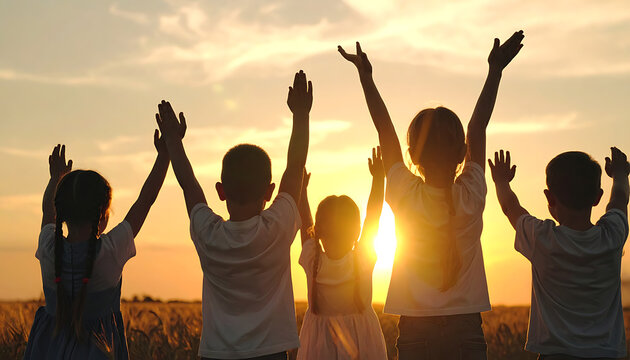 Group of diverse children with arms raised in celebration against a golden sunset, representing joy and togetherness