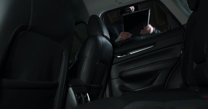 Car items theft - robber steals laptop from car interior through window