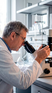 Mature scientist adjusting a sample under a microscope in a laboratory