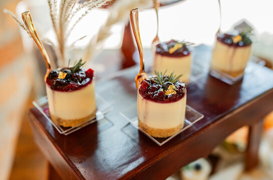 Postres individuales gourmet de cheesecake con frutos rojos y decoraci&oacute;n elegante para catering y eventos