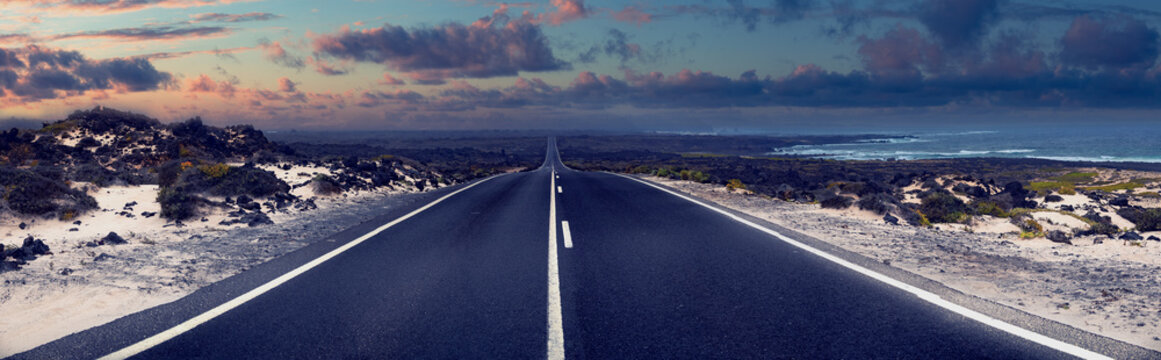  Carretera costera vac&iacute;a،paisaje panor&aacute;mico al amanecer, aventura de viaje. Lanzarote, islas Canarias. Carretera vac&iacute;a a lo largo de la costa al amanecer. Representa aventura, libertad y viajes.