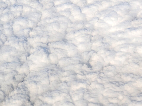 Soft white cloud layer seen from above, full frame aerial texture with creamy billows and gentle shadows, abstract sky background for weather, atmosphere, aviation, climate, dreamy backdrop, no people