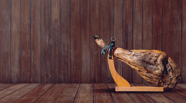  Pata de jam&oacute;n ib&eacute;rico sobre fondo de suelo de madera. Jam&oacute;n curado sobre fondo de tablones de madera. Evoca la tradici&oacute;n r&uacute;stica y la gastronom&iacute;a espa&ntilde;ola.