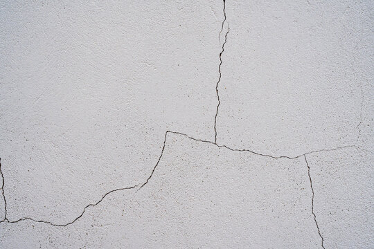 Textura de pared blanca con grietas irregulares y acabado de estuco envejecido para fondo abstracto