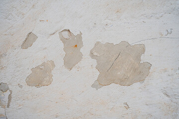Textura de pared blanca con pintura descascarada y revoque deteriorado sobre superficie de cemento © Manuela