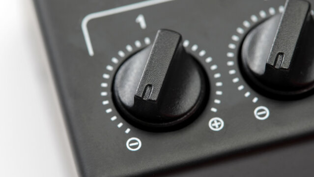 Black rotary control knob set to zero on electronic device, macro closeup of adjustment dial with level scale, minimal appliance interface, audio mixer or equipment control concept, no people