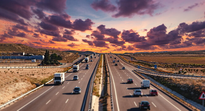 Tr&aacute;fico en la autopista,atardecer,cielo dram&aacute;tico,autom&oacute;viles,paisaje de autopista.Autopista transitada con tr&aacute;fico bajo un cielo dram&aacute;tico al atardecer.Representa viajes,transporte e infraestructuras