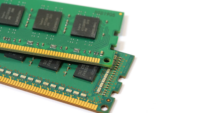 Two generic green DDR RAM sticks stacked on white background, closeup of PC memory modules with gold contacts, chips and circuits, hardware upgrade, chip shortage and rising prices concept, no people
