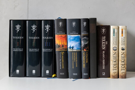 J.R.R. Tolkien books arranged on white shelf, frontal view of The Lord of the Rings and History of Middle-earth volumes with Polish editions, fantasy literature collection, author branding, no people
