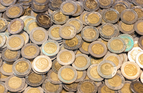 Large pile of 5 Polish zloty coins, full frame closeup of bimetal PLN currency with eagle emblem and number five, money background for savings, finance, cash economy and inflation concept, no people