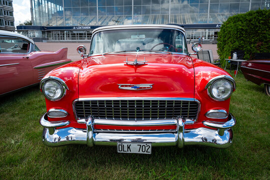 Stockholm, Sweden - August 2, 2025: Red 1955 Chevrolet Bel Air with iconic chrome grille and hood ornament, front view at Stockholm Car Meet, Solvalla