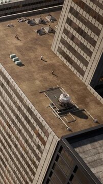 The scene shows rooftops of tall buildings in a city. Air conditioning units and structural details are visible. The setting appears to be during daylight hours with some shadows.