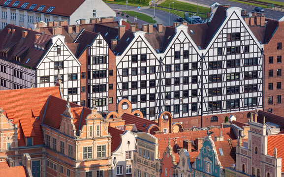 Traditional brick granary buildings with timber framed facades on the Motlawa River waterfront in the historic center of Gdansk, Poland.