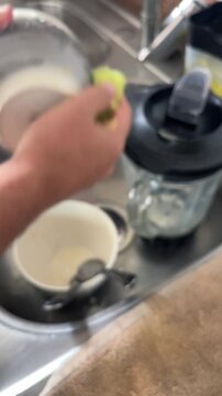Blurred background of man washing dishes in kitchen sink