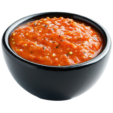 Glossy black bowl filled with vibrant textured red salsa with visible seeds isolated on white background
