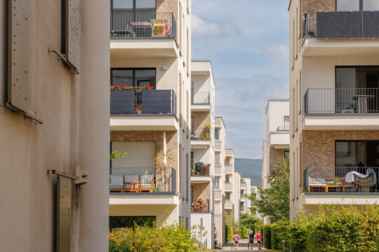 Modern buildings in a residential area with balconies and greenery during the day