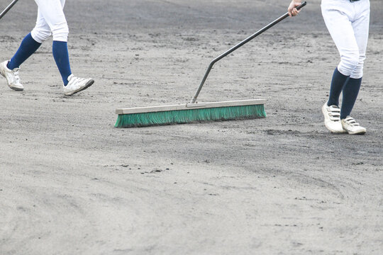 野球場のグラウンド整備をする選手