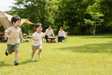 Obraz premium キャンプ場の芝生で走る子どもたち