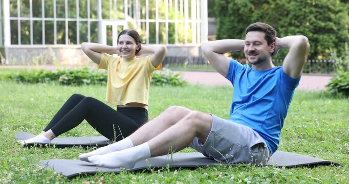 Happy couple doing morning exercises in park