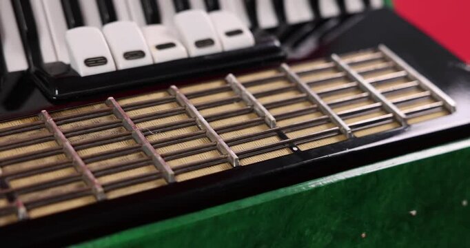 Piano accordion on red background, closeup. Camera moving down and right
