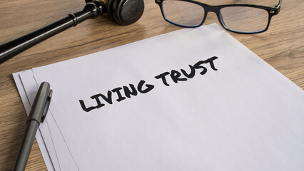 Fototapeta na wymiar Living Trust legal document on wooden desk with gavel and glasses