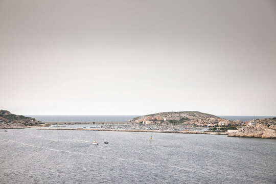 Panorama of Port Frioul on Ratonneau Island, with marina, boats, rocky coastline, waterfront buildings, harbor entrance and Mediterranean water near Marseille on iles du frioul, in france.