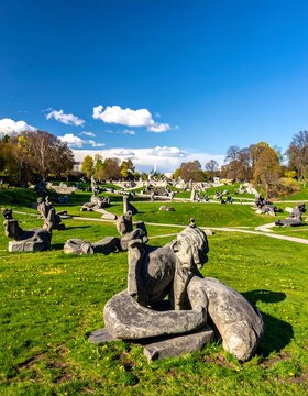 Stone Sculptures in a Grassy Park Under a Blue Sky