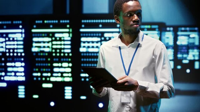 African American engineer inspects high performance supercomputers in a data center, supporting scientific simulations, rendering workloads and intensive computing tasks during server hub.
