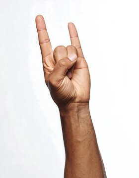 A Tanned Hand Making the Rock Horns Gesture Against a White Backdrop