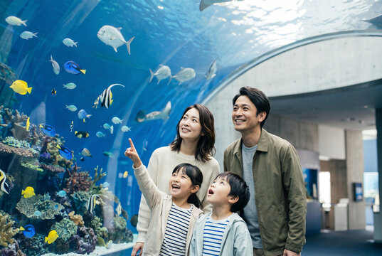 水族館の水中トンネルで魚を見る家族 Generative AI