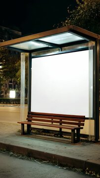 An empty bus stop bench at night.