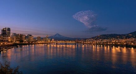 Obraz premium City skyline and mountain peak under twilight sky, water reflecting lights