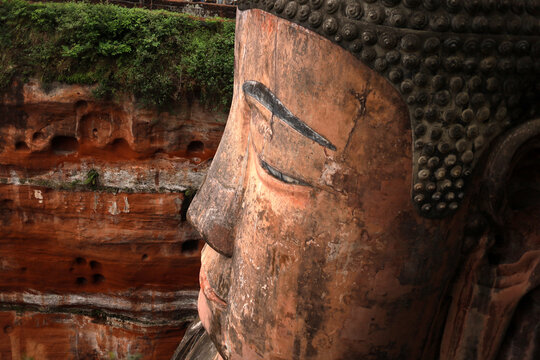 Leshan Giant Buddha carved into the red sandstone cliff in Sichuan, China.